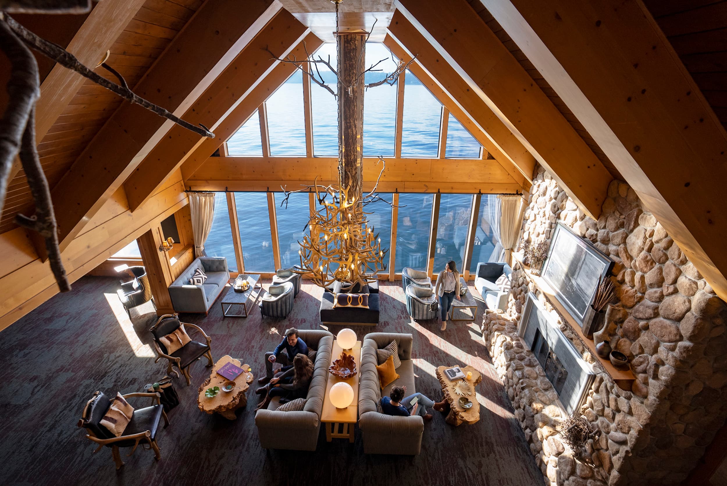 The Edgewater lobby with tall vaulted ceilings and several different seating areas and large windows looking out to the water