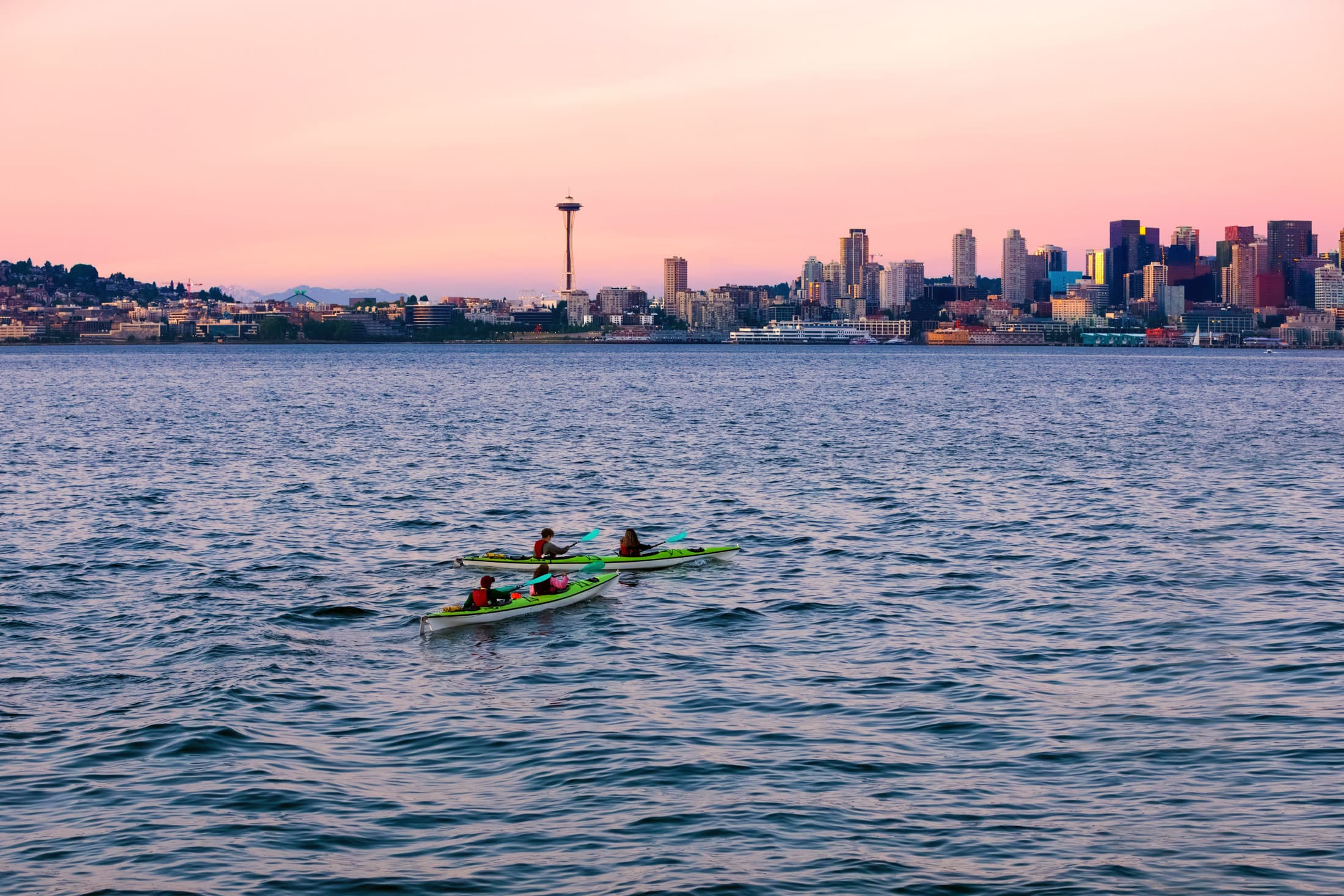 2 people kayaking on lake union with city background