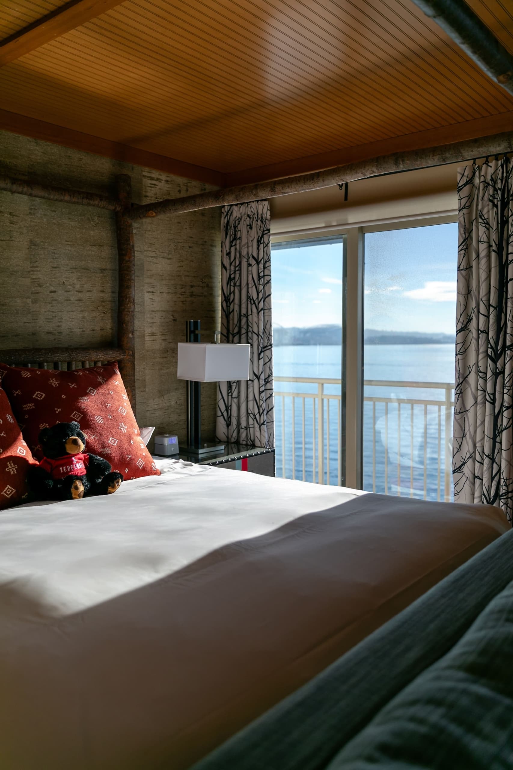 A queen bed in a room at Edgewater with a view of the water
