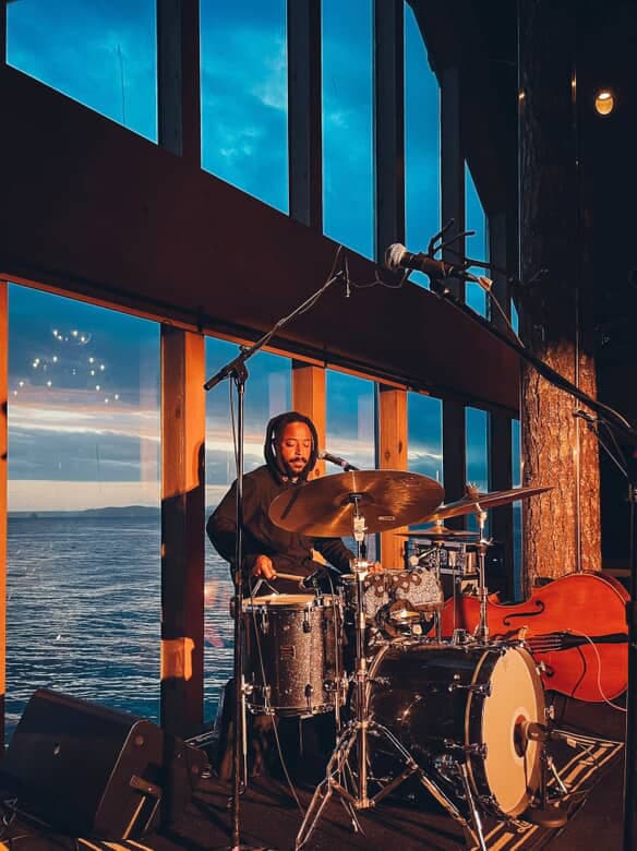 A man playing drums at night in the Edgewater lobby
