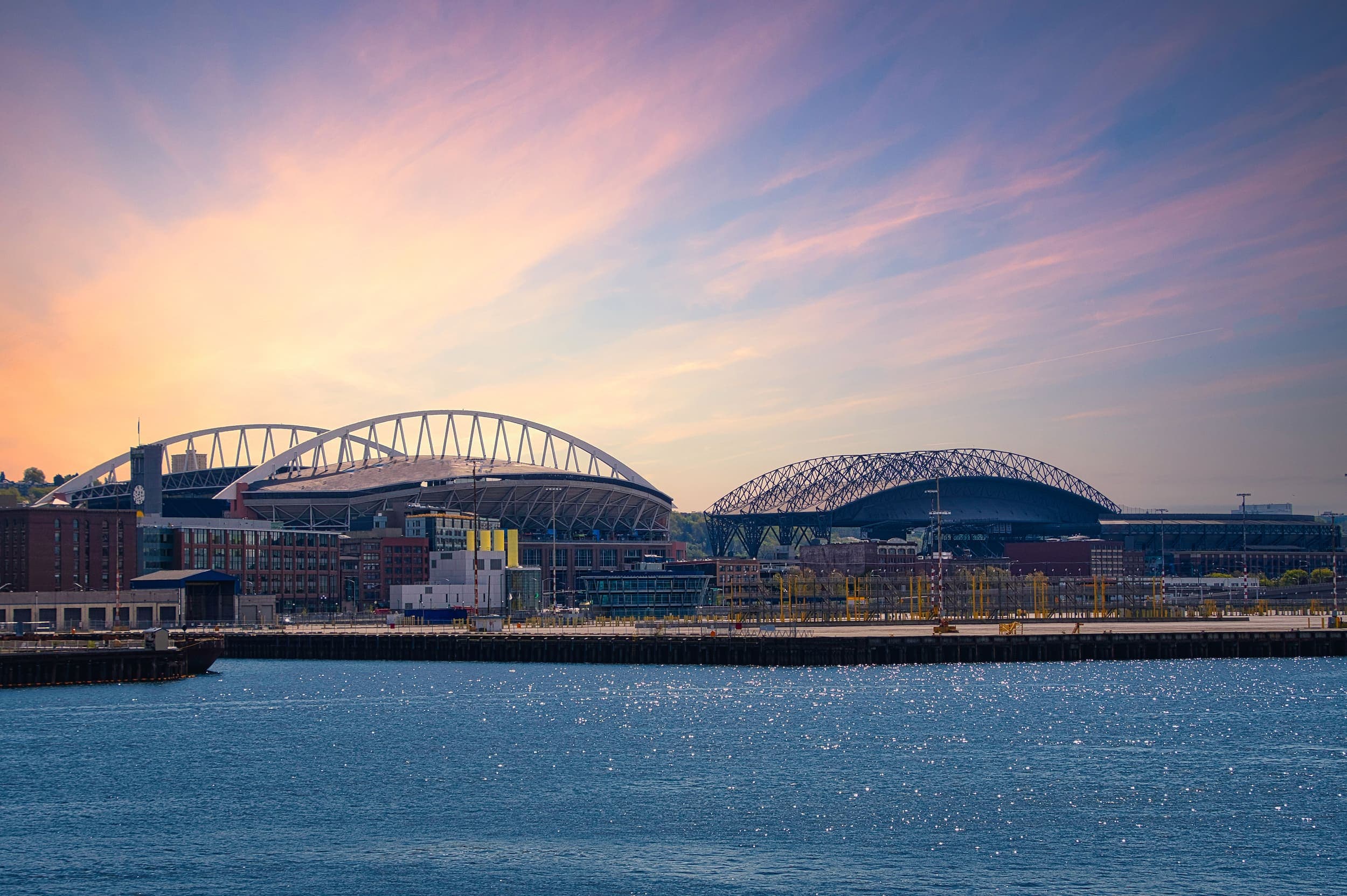 A view of the boardwalk from the water with a beautiful pink sky