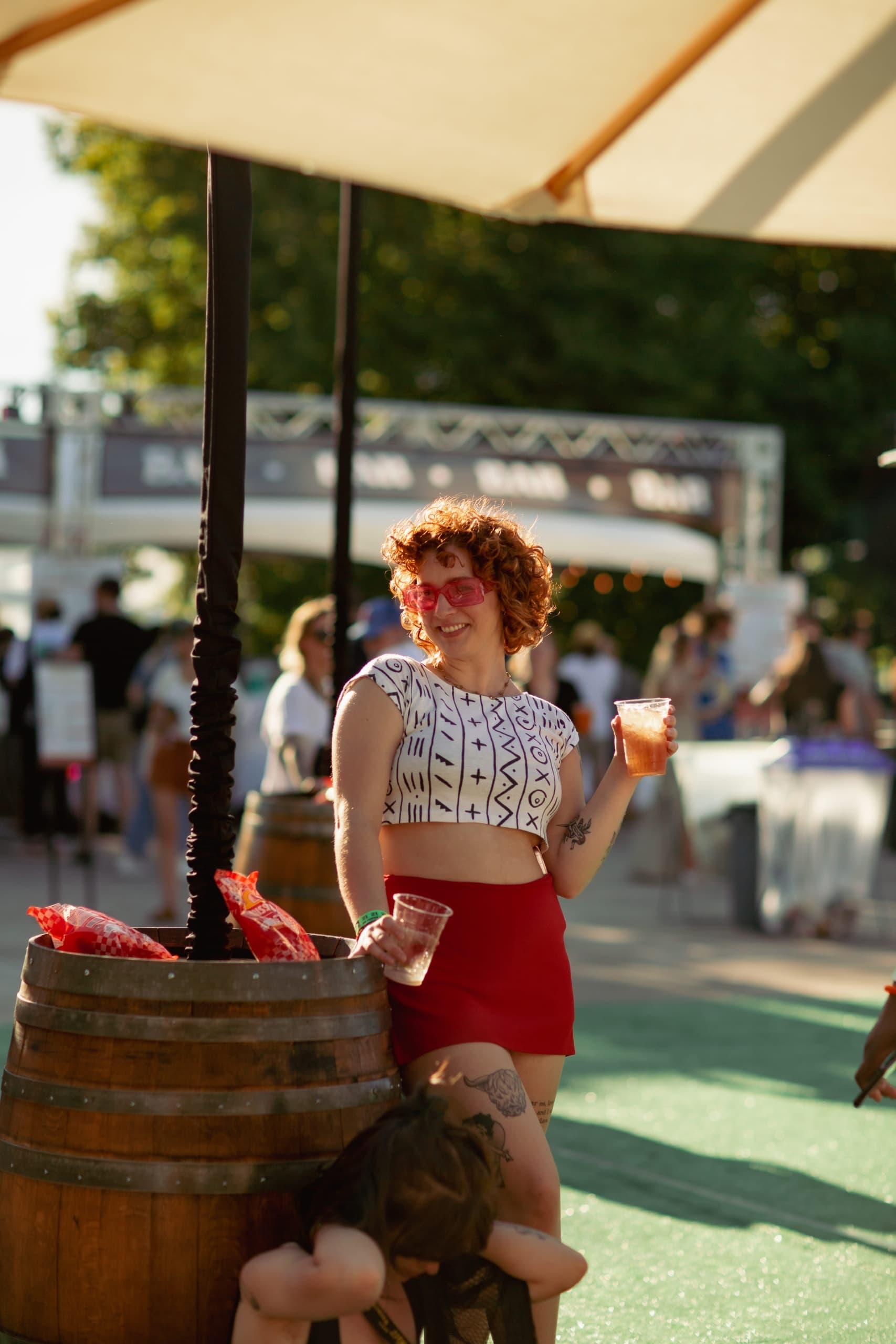 Two people hanging out at a festival with drinks