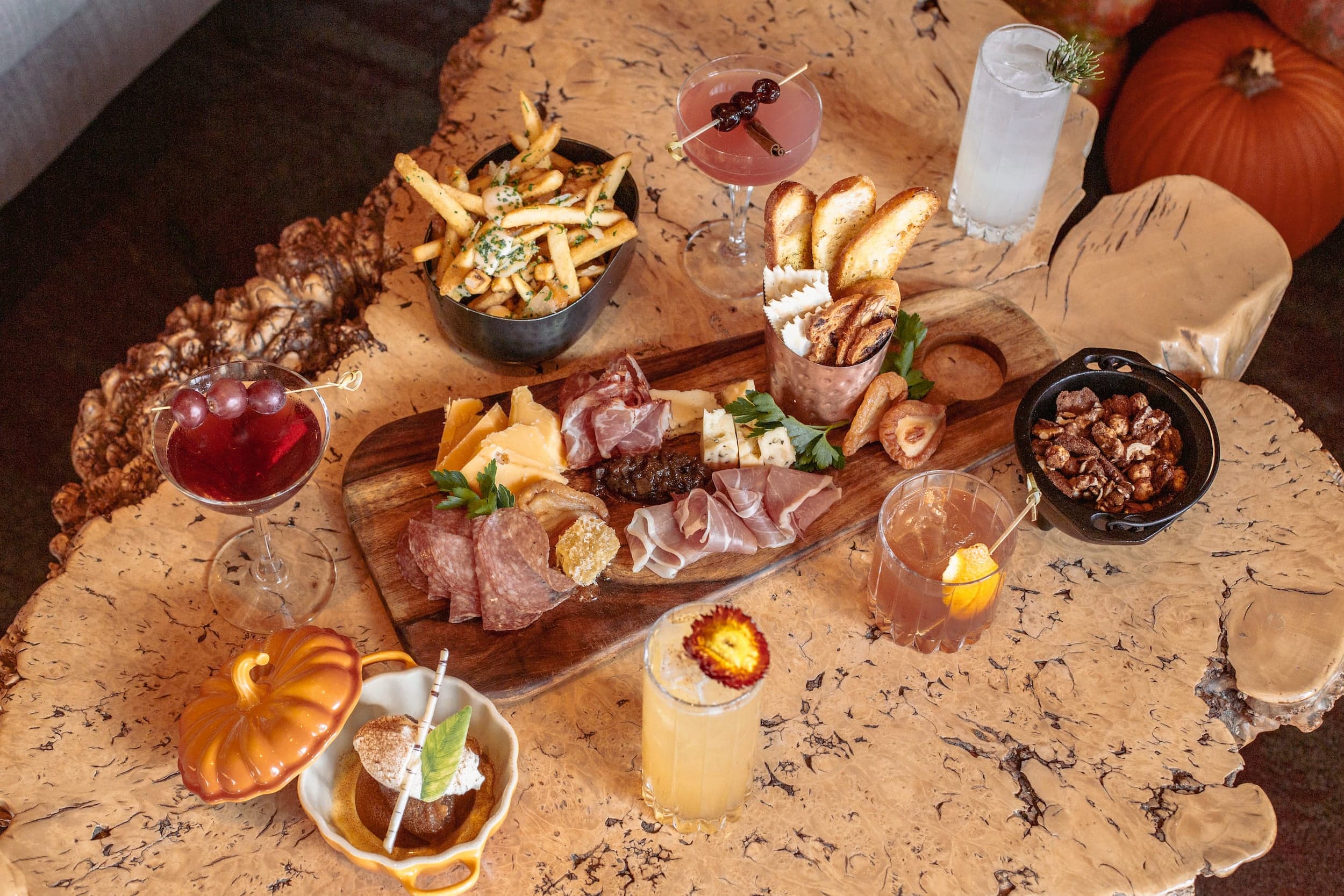 A spread of cured meats, side of fries, and 5 cocktails at Edgewater