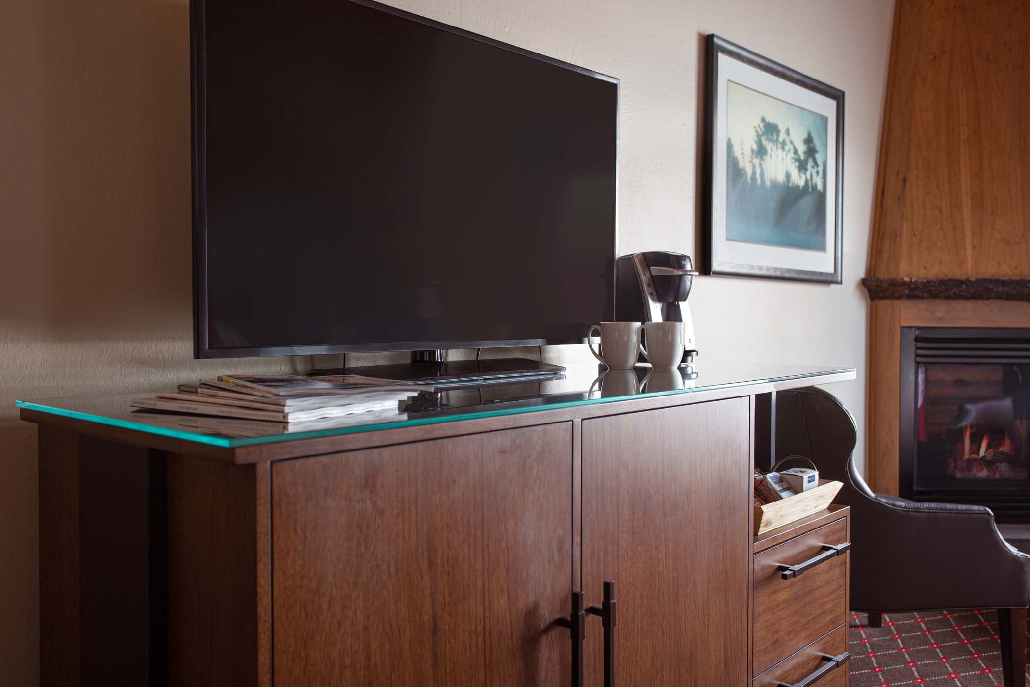 A TV and coffee machine on a cabinet in a room at Edgewater