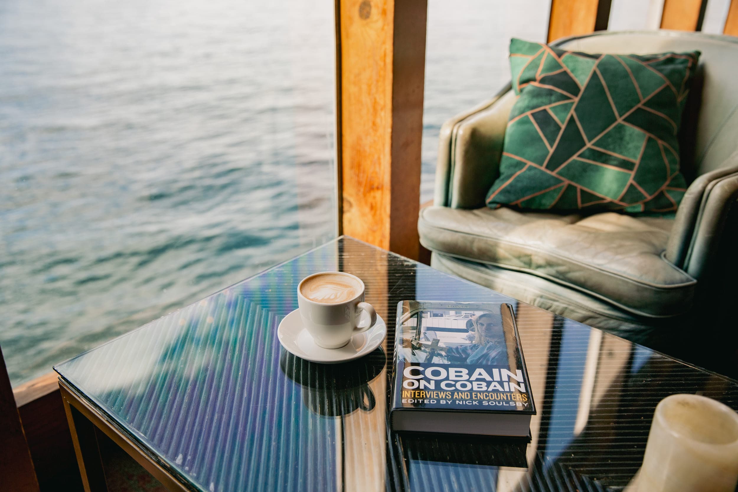 A hot beverage and a book on Kurt Cobain on a table at Brim