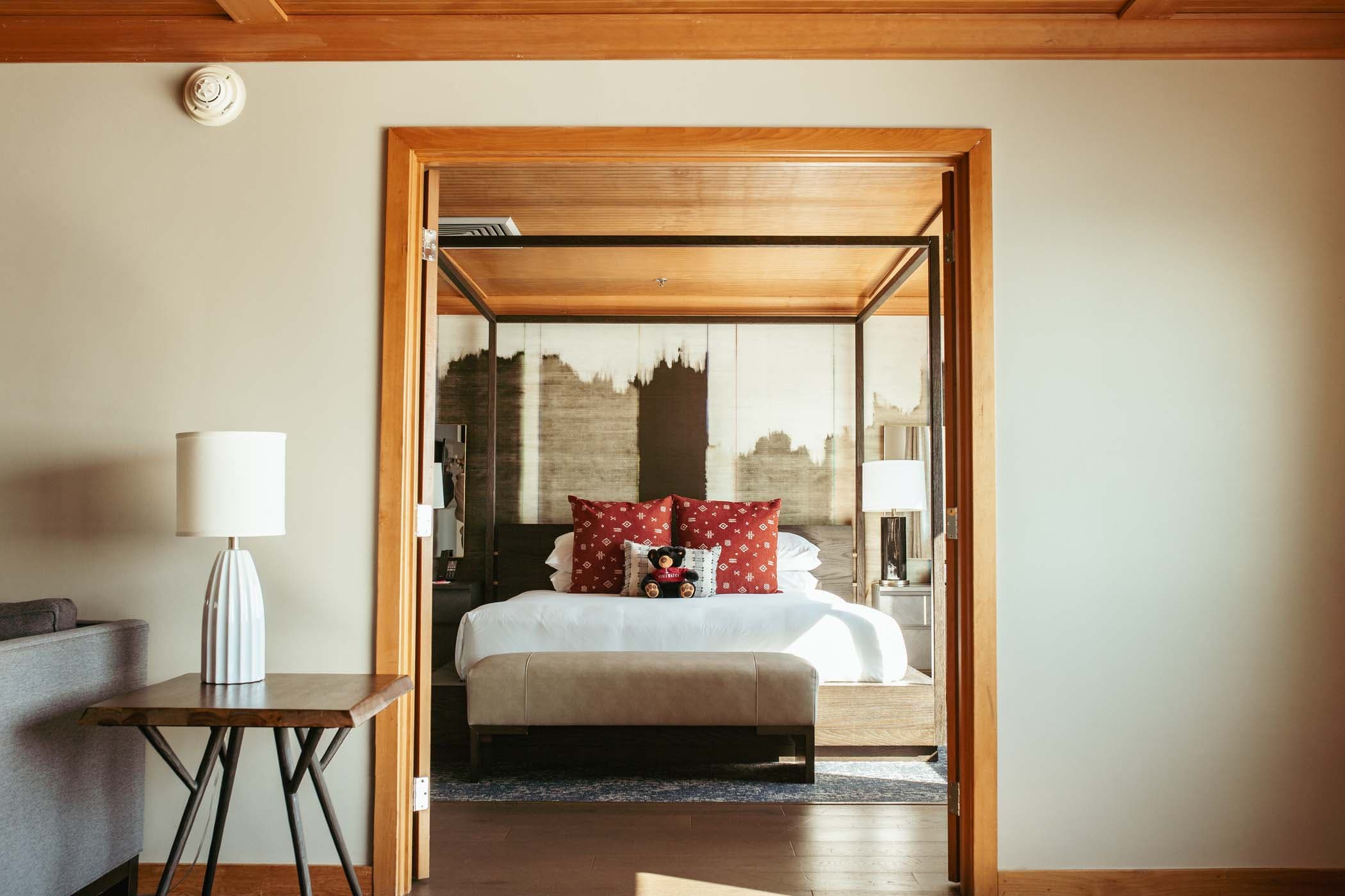 A large bed with a canopy and large bright windows with stunning views of the water at Edgewater