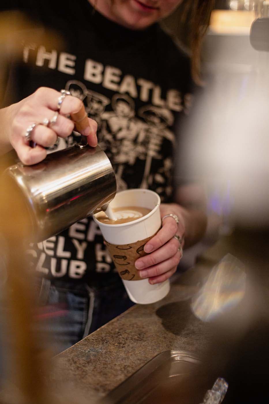 A barista making a cappuccino at The Brim Coffee Shop