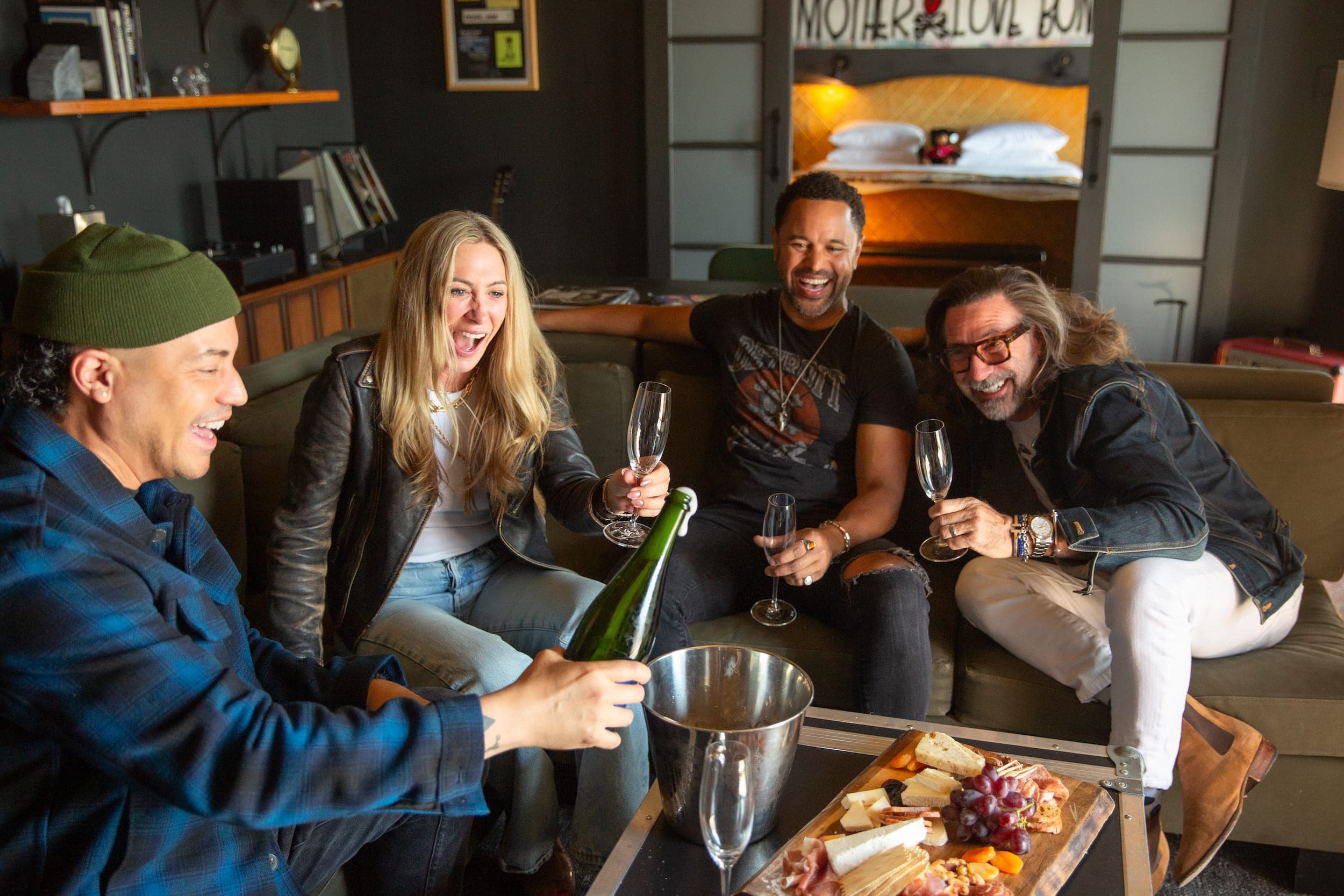 A group of 4 guests in the Pearl Jam suite enjoying some wine and food