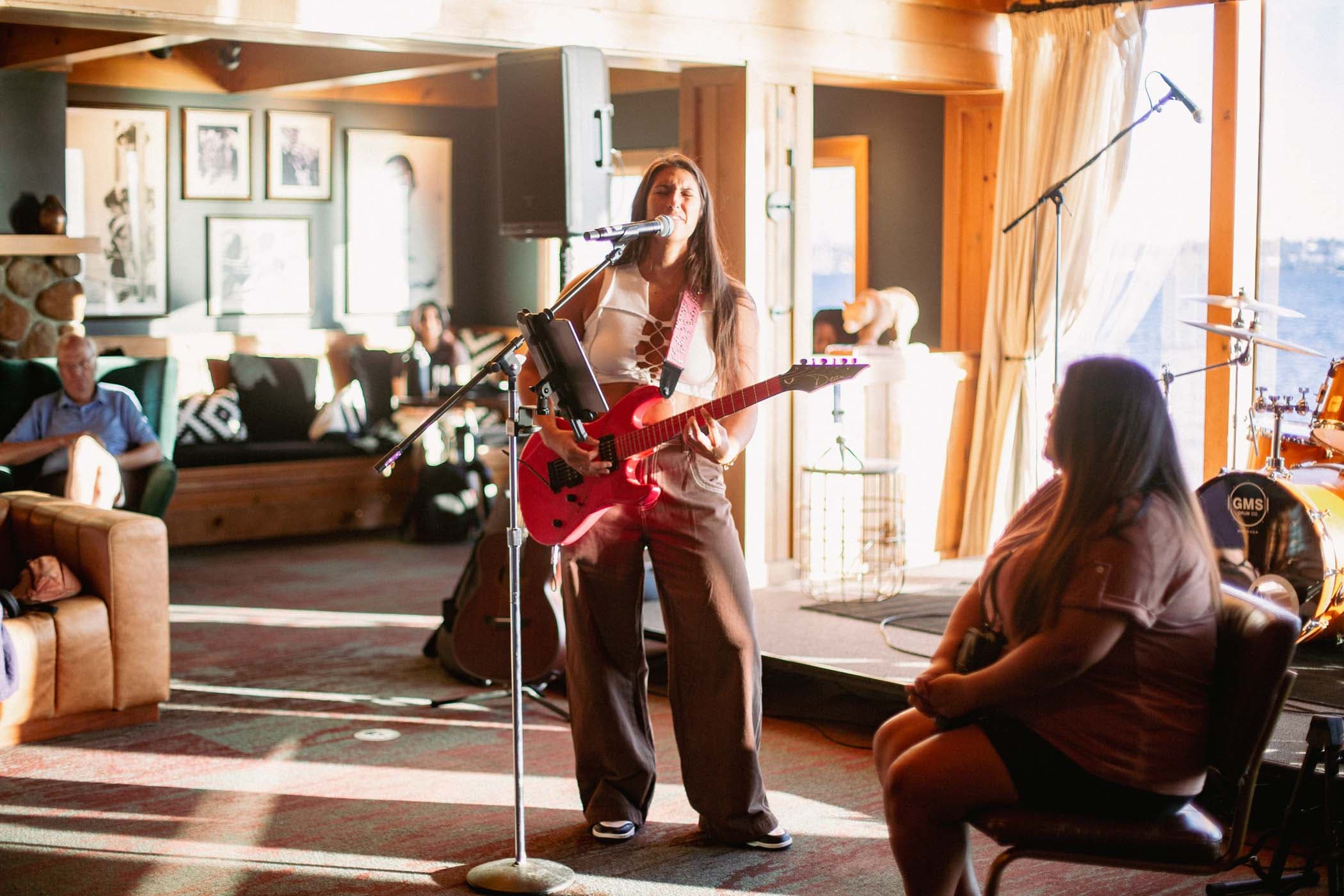 A woman singing on stage to a few people