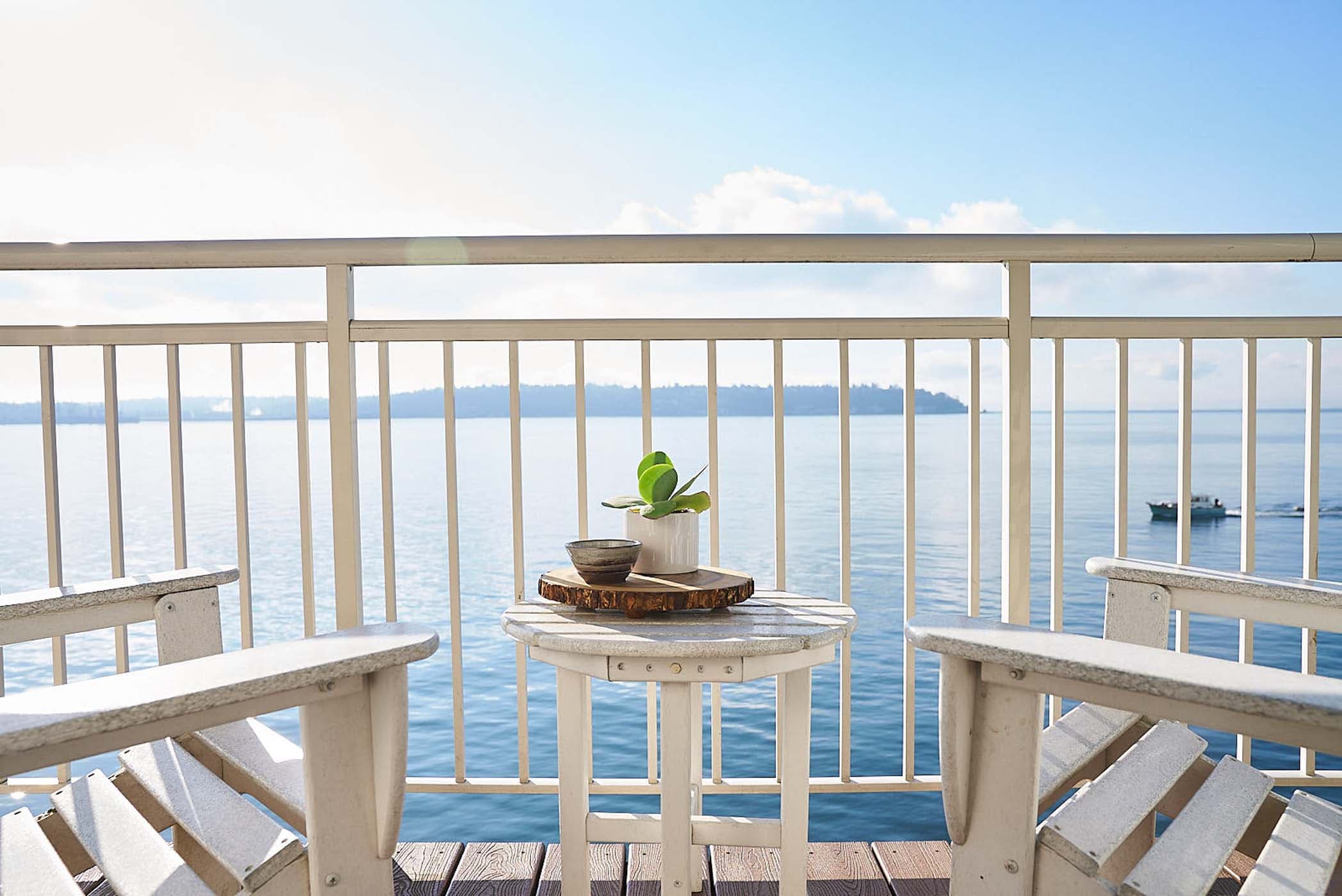 Over Water Balcony View with two deck chairs and a small table at Edgewater
