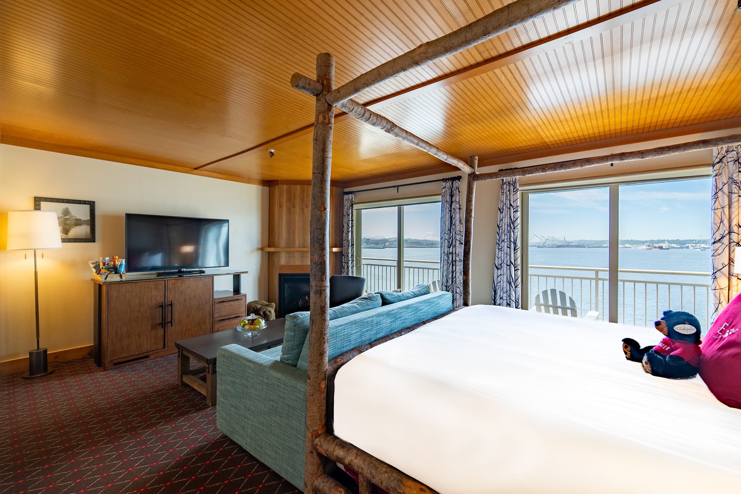 A large suite with a water view and a wood canopy over the bed at Edgewater