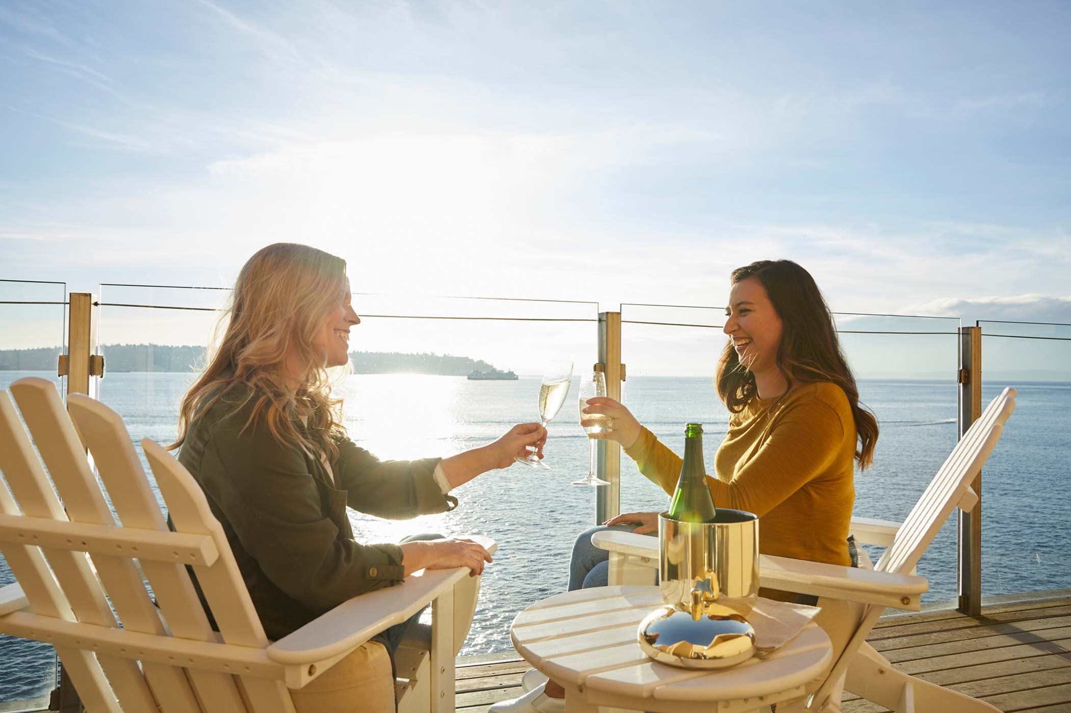 Two people having a drink on the balcony of the Penthouse suite at Edgewater