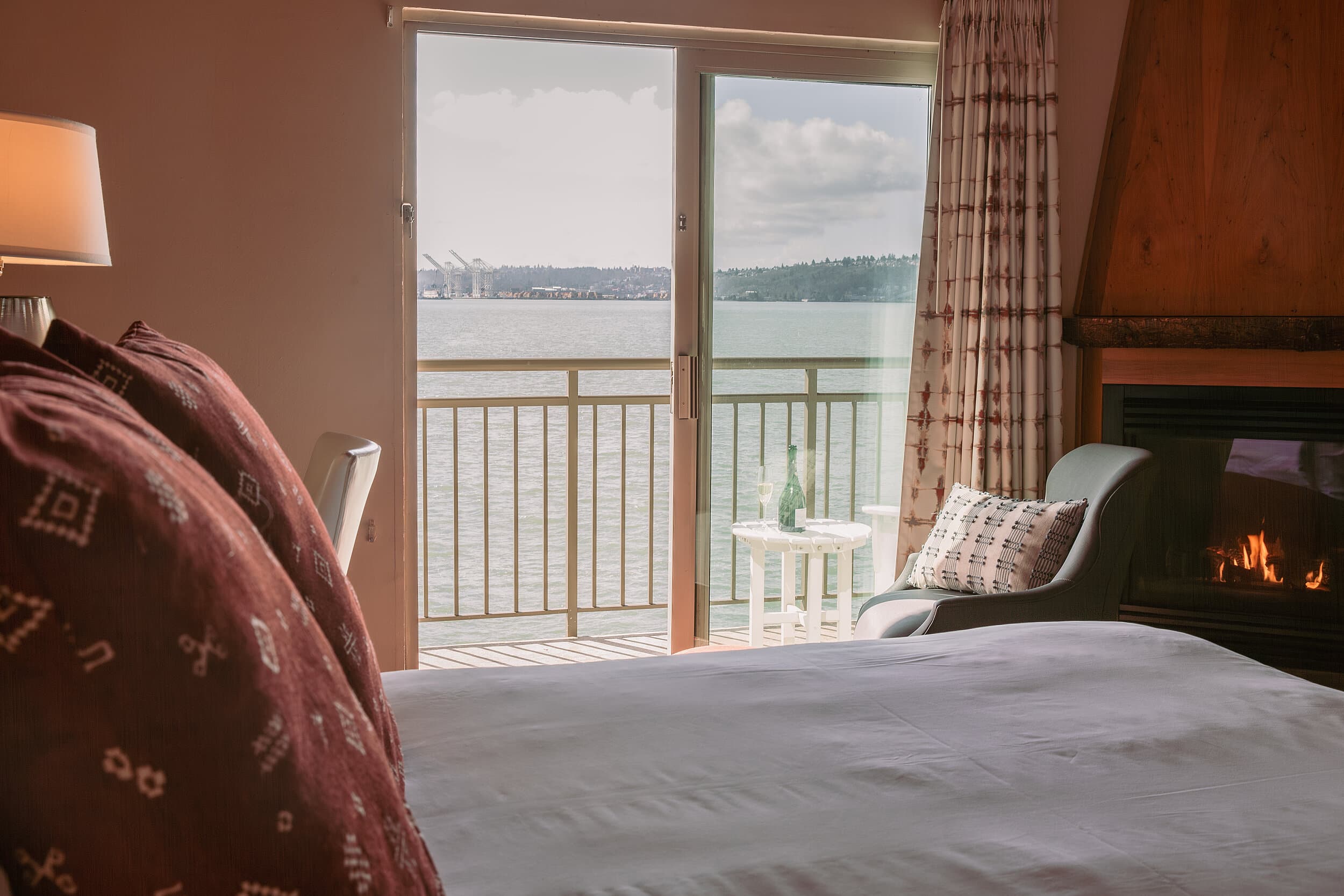Guest room with a wood-burning fireplace and private balcony overlooking Elliott Bay at The Edgewater Hotel in Seattle