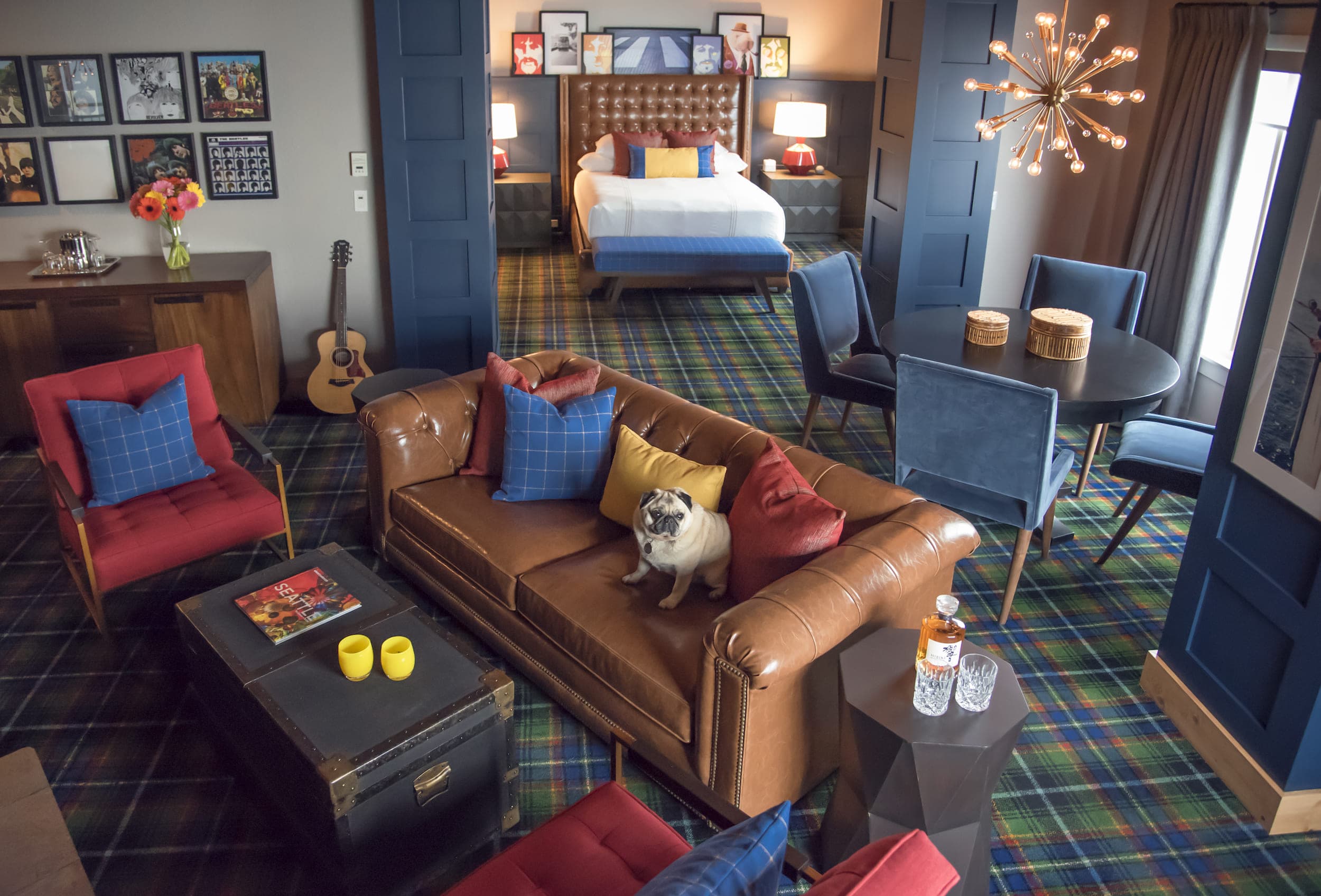 The Beatles suite at Edgewater with a round table, fireplace, lounge space, and bright Beatles inspired bedroom