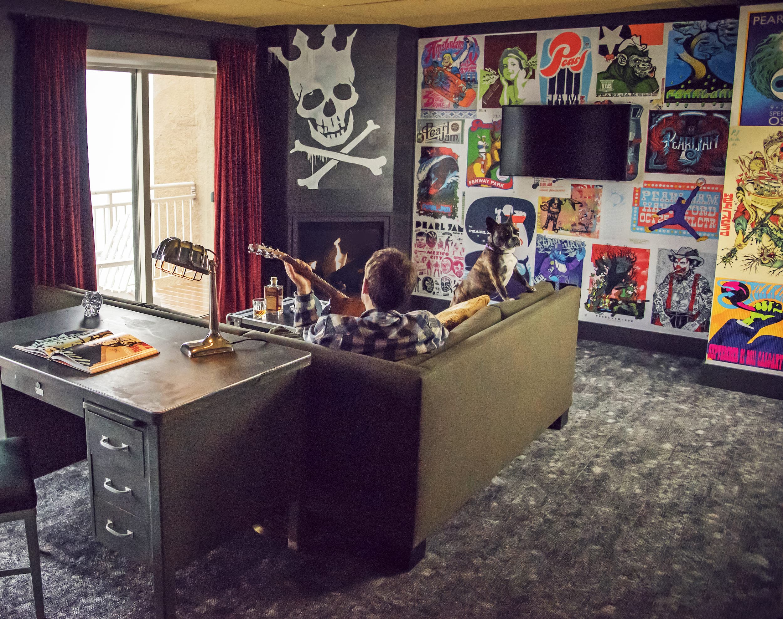 A man and his dog sitting on a couch in the Pearl Jam inspired room at Edgewater