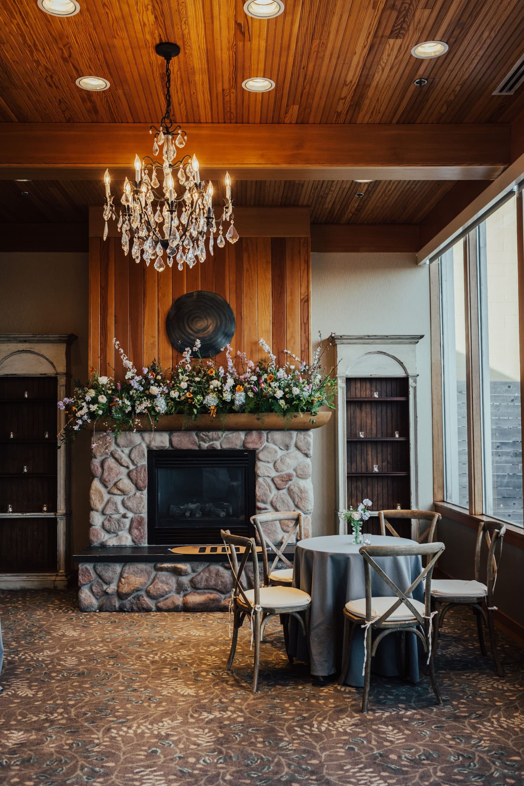 An event space with a stone fireplace, wrm decor over looking the water at Edgewater