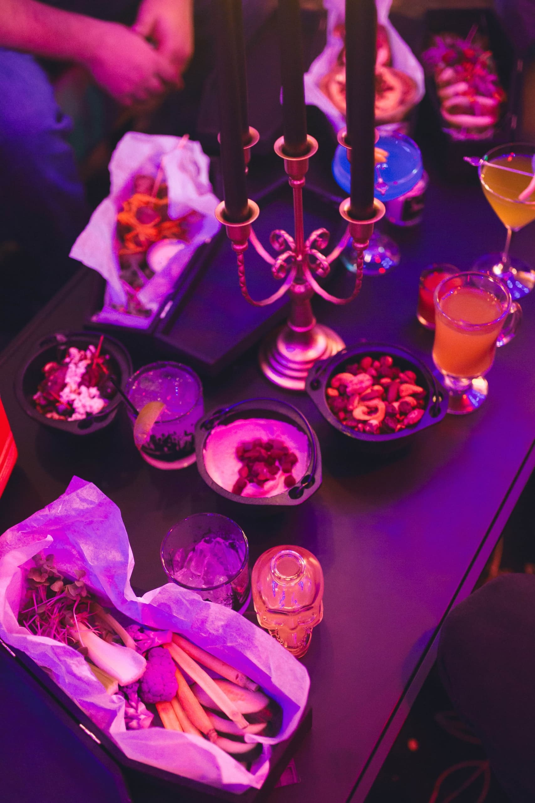 Halloween cocktails and shareable snacks on a candlelit table at The Edgewater Hotel Seattle