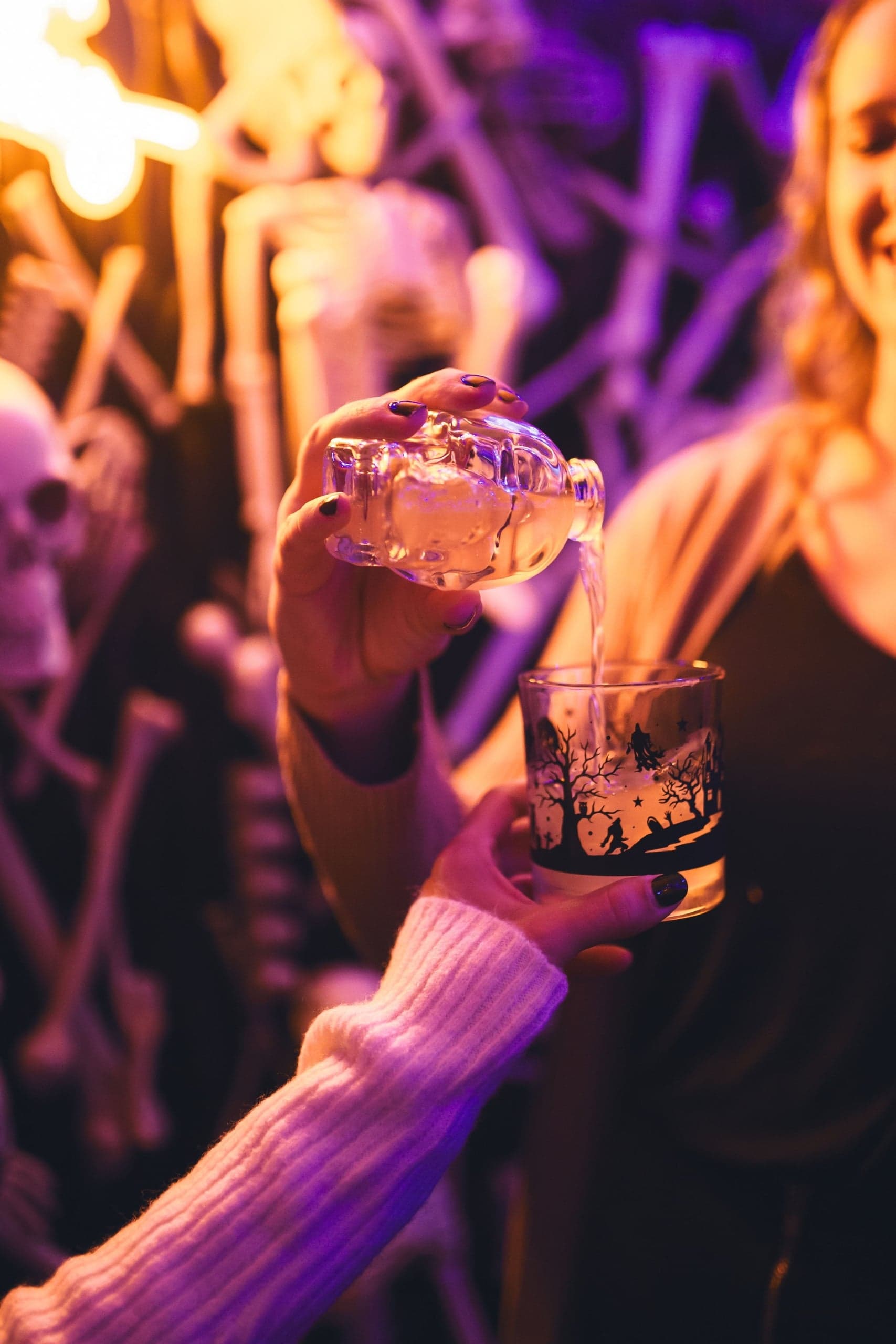 Skull-shaped bottle pouring a Halloween cocktail into a spooky glass at The Edgewater Hotel Seattle