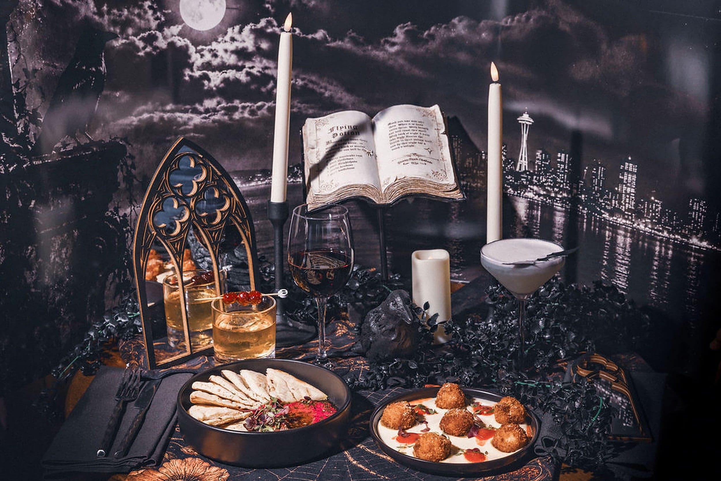 Haunted Lobby Bar Halloween tablescape at The Edgewater Hotel Seattle with seasonal cocktails, candlelight, and Space Needle skyline backdrop