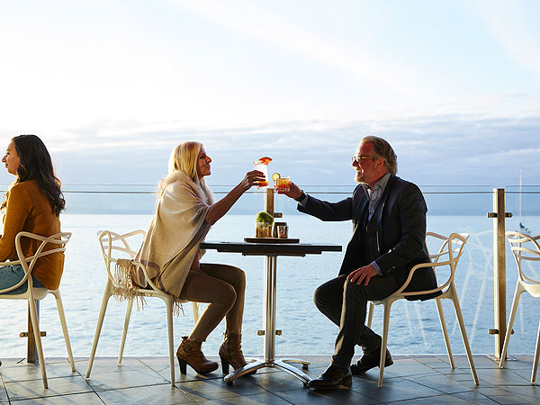 Couple Toasting On The Balcony Outside At Six Seven Restaurant.
