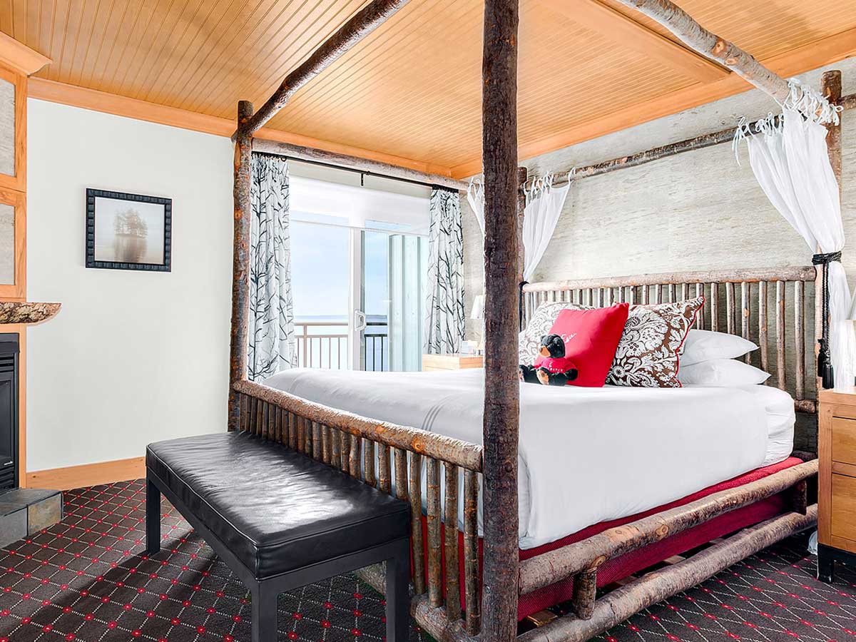 Room with a rustic four poster bed, at the Edgewater Hotel