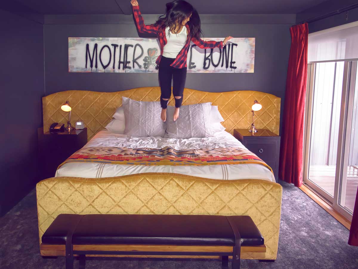 Perl Jam guestroom bed with girl jumping on bed.
