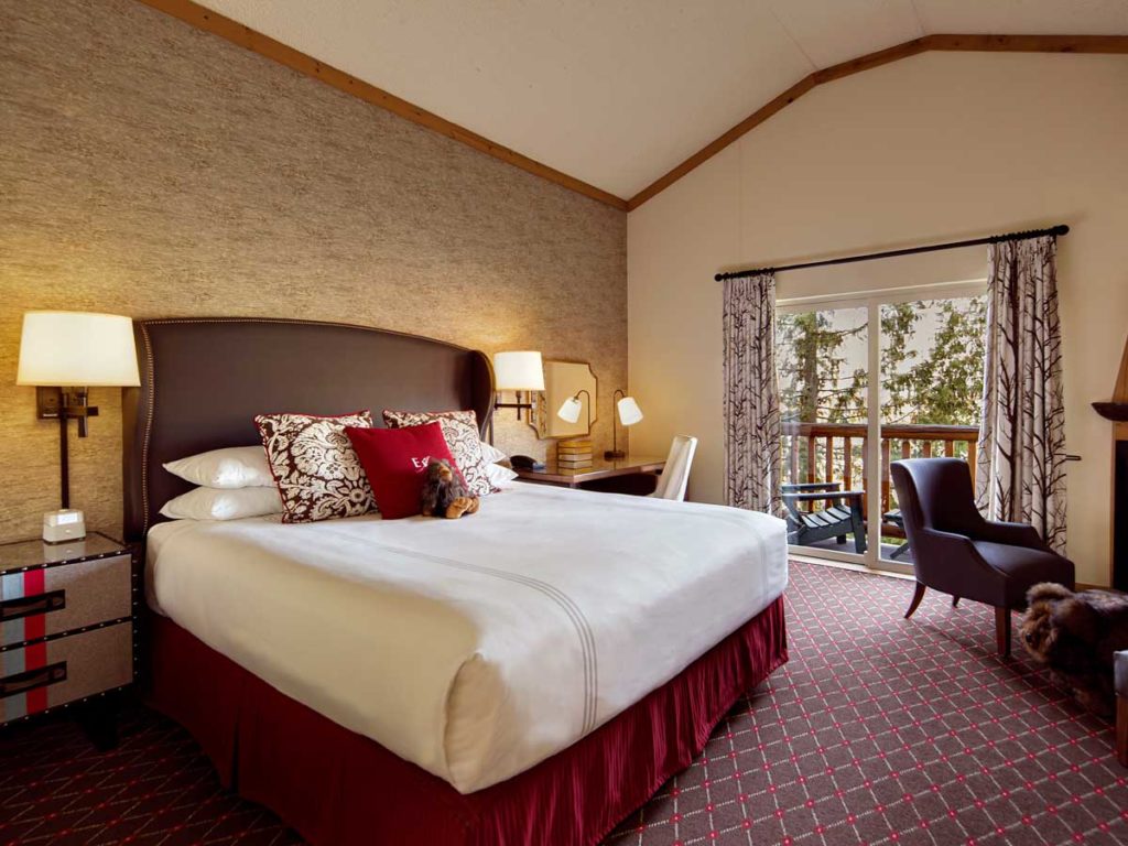 Guest room bed with balcony view.