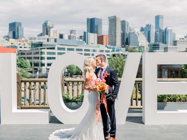 Bride And Groom In Front Of Love Sign.