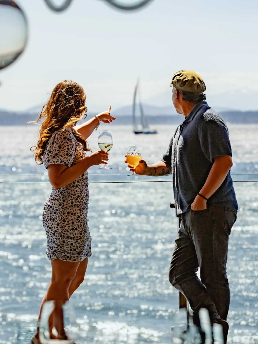 Couple looking at a sailboat on the deck at the Edgewater Hotel
